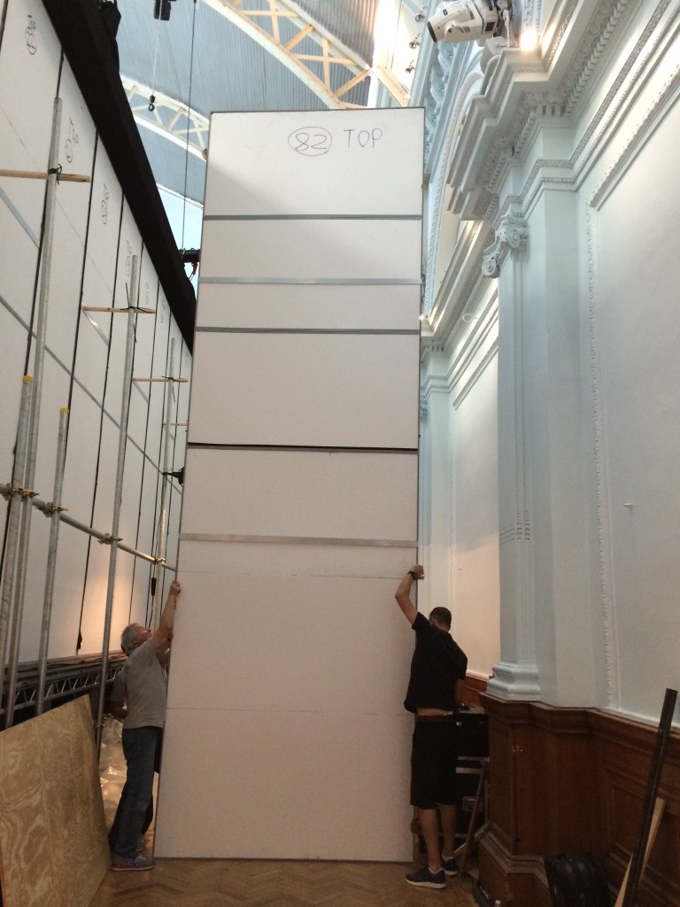 Foil mirrors (rear view) being lifted into position for an exhibition.